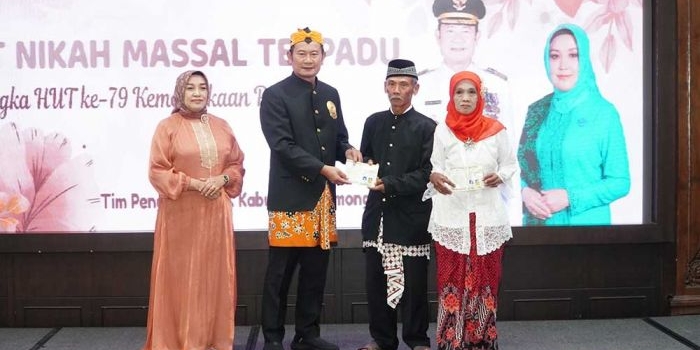 Bupati Lamongan Yuhronur Efendi saat menyerahkan dokumen pernikahan kepada mempelai tertua pada itsbat nikah terpadu di Pendopo Lokatantra, Kamis (22/8/2024).