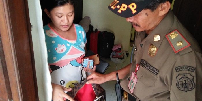 Petugas mengecek kartu identitas semua penghuni kost, serta memeriksa barang-barang milik penghuni kos.