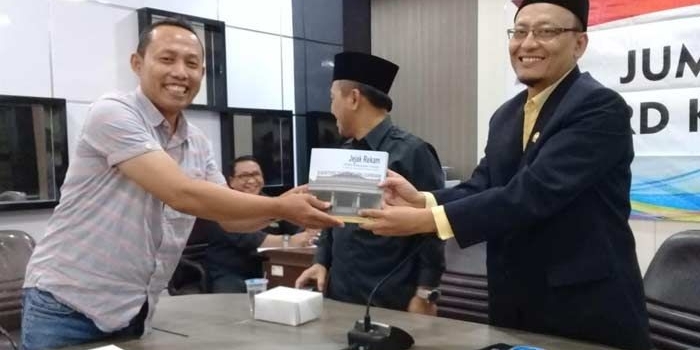 Sekretaris KWG, M. Syuhud Al-Manfaluty menyerahkan buku rekam jejak DPRD Gresik kepada Ketua DPRD Gresik, H. Ahmad Nurhamim. 