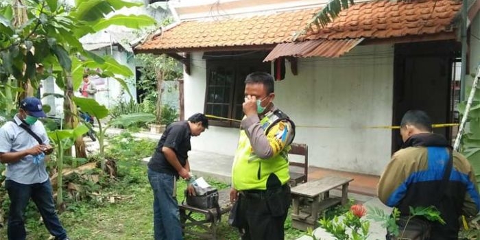 Petugas memasang garis polisi di kos-kosan tempat korban tinggal. foto: RONY S/ BANGSAONLINE