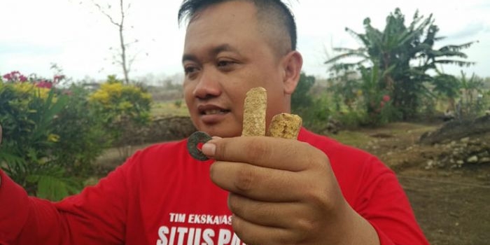 Tim eskavasi yang menunjukkan temuan berupa uang gepeng dan pasak. (foto: ist).