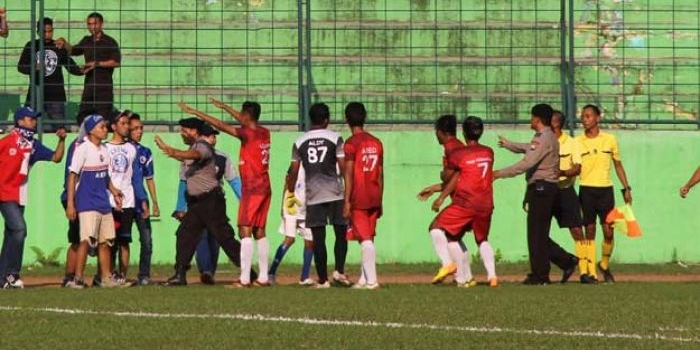 Kericuhan terjadi akibat masuknya supporter ke lapangan. 