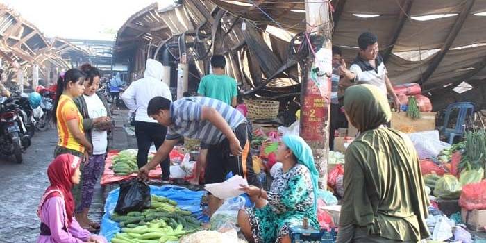 TERPAKSA: Sejumlah pedagang sayuran nekat berjualan dekat puing kebakaran Pasar Baru Porong Sidoarjo meski sadar bahaya mengancam sewaktu-waktu, Jumat (11/11). foto: mustain/ bangsaonline