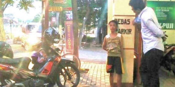 Reyang Permana saat ditemui di tempat kerjanya mengelap kendaraan di Apotek Jl Adityawarman Jombang. foto: romza/ bangsaonline