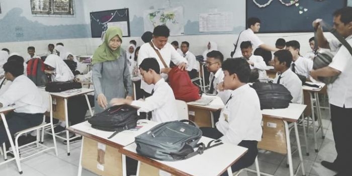 Petugas OPD gabungan Kota Surabaya saat memeriksa HP milik para siswa.