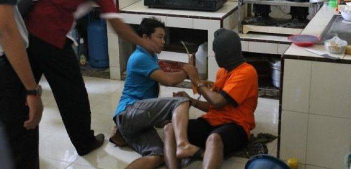 Tersangka saat memperagakan pembunuhan terhadap korban. (Try Susanto/BangsaOnline.com)
