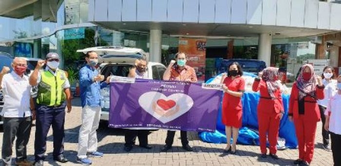 Susana, manajemen Dealer Arina Toyota Gresik saat menyerahkan sembako secara simbolis untuk warga Sidomoro, Kebomas. foto: ist.