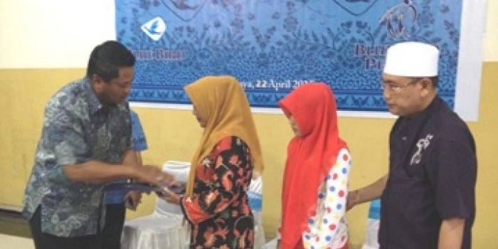 Asia (istri korban) menerima santunan dari pihak Blue Bird. (Rusmiyanto/BANGSAONLINE)
