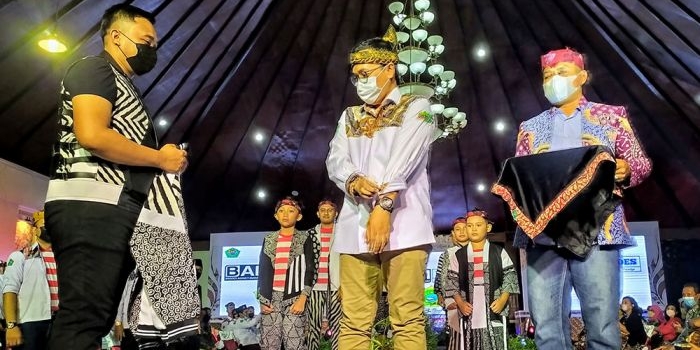 Bupati Pamekasan, Baddrut Tamam, saat menerima baju batik dari Bagus Agency Manajemen.
