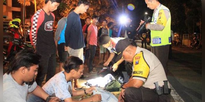 Petugas saat memeriksa beberapa pemuda yang diketahui pesta minuman keras. foto: ARIF KURNIAWAN/ BANGSAONLINE