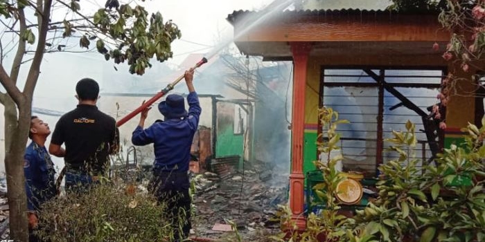 Petugas melakukan pembasahan di sisa-sisa api yang membakar SMPN 1 Balongbendo.