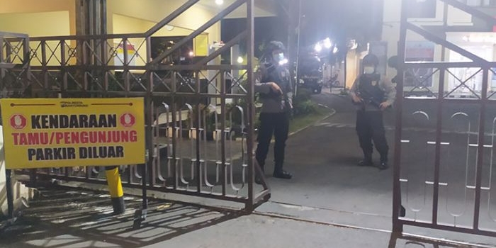 Personel bersenjata dan alat pelindung lengkap berjaga di gerbang masuk Polresta Banyuwangi.