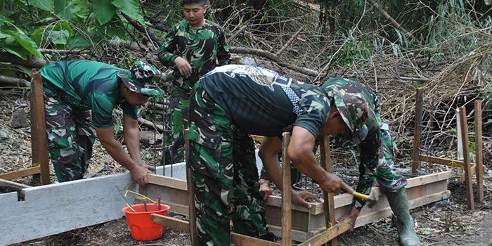 Satgas TMMD ke-115 saat membuat gapura di Desa Kramat, Pulau Mengare, Kecamatan Bungah, Kabupaten Gresik.