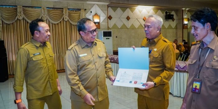Sekda Achmad Washil Miftahul Rachman MT didampingi  Kepala BKPSDM Agung Endro Dwi Setyo Utomo, menyerahkan SK pensiun kepada Kadisperta Eko Anindoto Putro. foto: ist.

