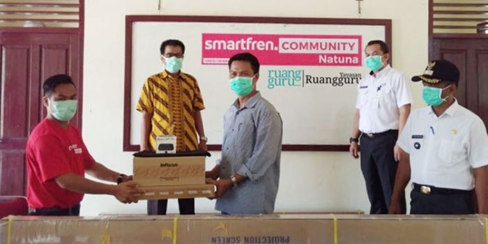 Sirojuddin, Leader Smartfren Community Natuna, menyerahkan bantuan secara simbolis kepada perwakilan sekolah di Natuna.