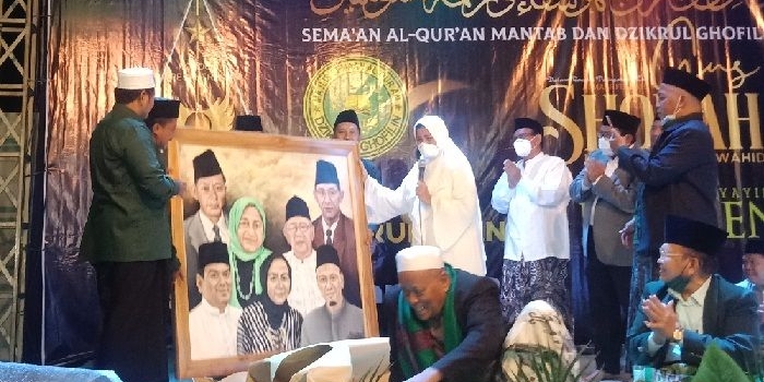 Bu Nyai Faridah saat menerima cenderamata berupa lukisan keluarga besarnya dari Ikapete Surabaya. 