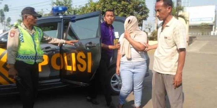 IMITASI. Tersangka Silvi Widiasari menutupi wajahnya ketika digelandang  petugas ke Polsek Porong. foto: catur andy/BANGSAONLINE