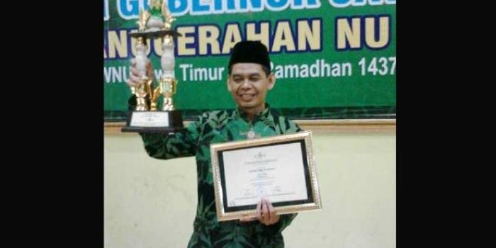 Sekretaris PCNU Magetan Ahmad Sudarto SPdI mengangkat piala dan piagam NU Award Jatim. foto istimewa