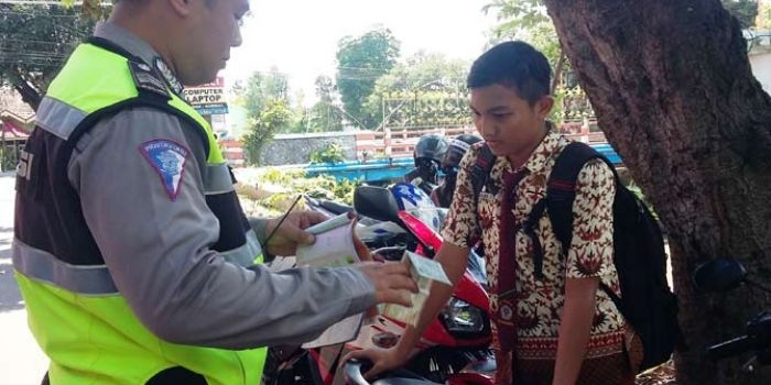 Pelajar SMP yang kena razia polisi dan ditilang karena tak memiliki SIM dan helm di Jl Raden Wijaya Kota Mojokerto, Rabu (11/1).