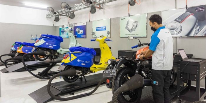 Seorang teknisi Piaggio sedang memeriksa kendaraan pelanggan yang diservis.