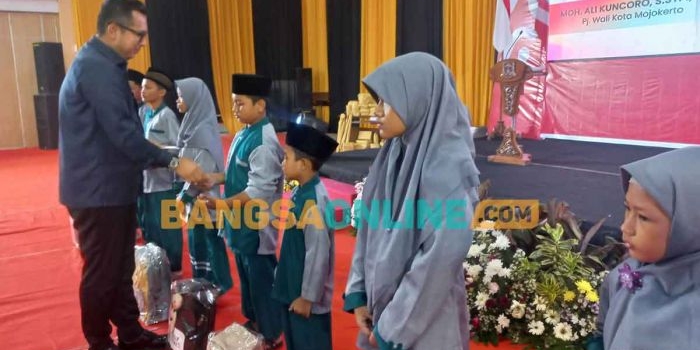 Pj Wali Kota Mojokerto, Moh. Ali Kuncoro, saat menyalurkan santunan kepada anak yatim. Foto: ROCHMAT SAIFUL ARIS/BANGSAONLINE