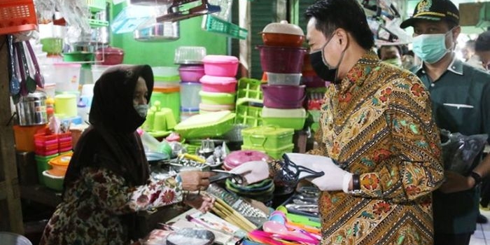 SOSIALISASI PSBB: Wabup Nur Ahmad membagikan masker sambil sosialisasi PSBB, di Pasar Krian, Selasa (21/4) lalu. foto: ist