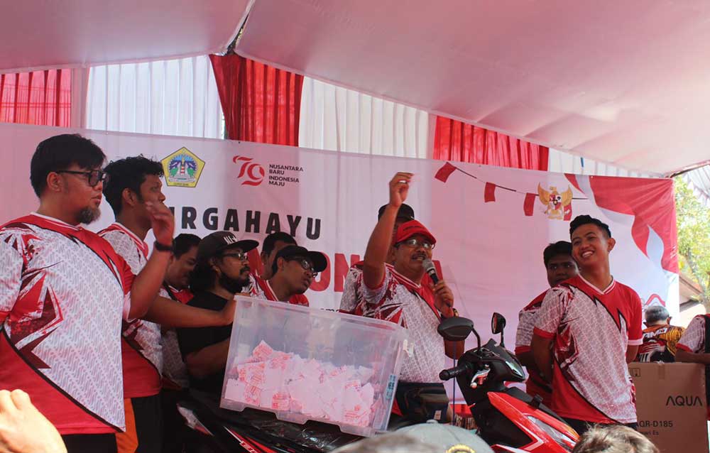 Kades Randuagung, Khambali, menunjukkan kupon saat pengundian hadiah utama jalan sehat berupa 1 unit sepeda motor. Foto: Ist.