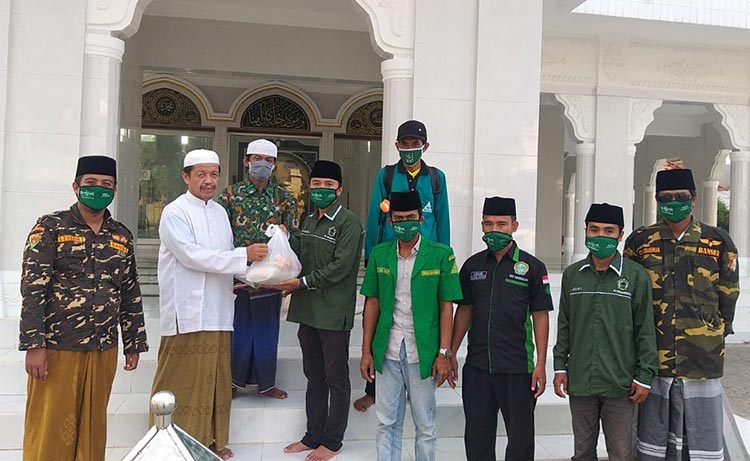 M. Amir, Koordinator Lapangan saat menyerahkan sembako kepada salah satu pengurus masjid di Kecamatan Klampis, Rabu (6/5/2020).