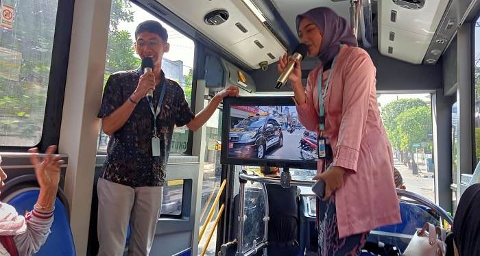 Dua mahasiswa Uniska yang menjadi petugas informasi di dalam bus Satria saat menjelaskan tempat-tempat bersejarah di Kota Kediri. Foto: Ist.