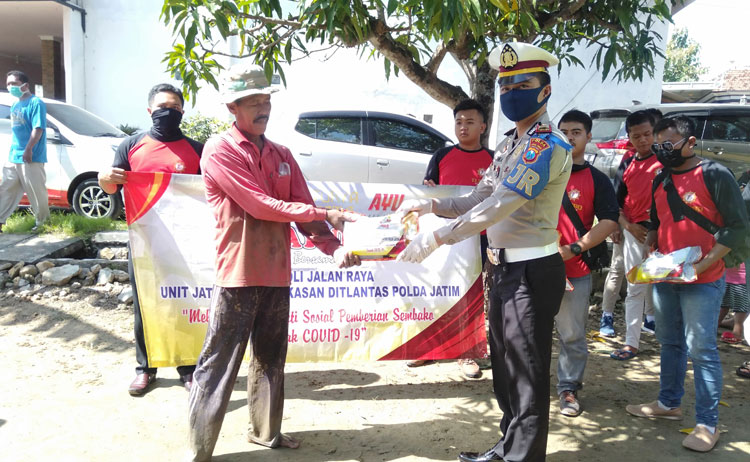 Kanit PJR Unit VIII Jatim AKP Andhika Ginanjar Wibisana bersama pemilik PR Ayunda Bambang Budiyanto saat membagikan sembako kepada masyarakat yang terdampak pandemi Covid-19. 