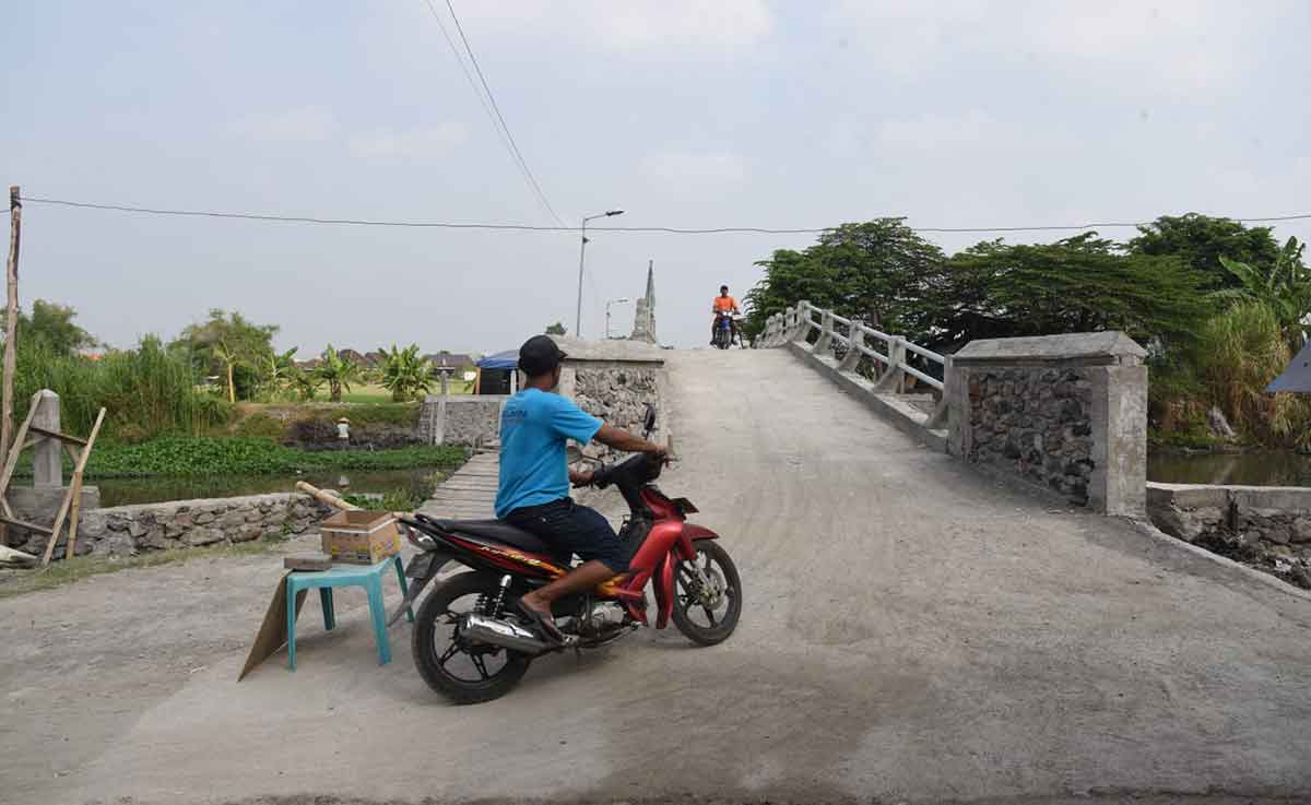 Pengendara sepeda motor melintasi jembatan di Desa Klurak, Kecamatan Candi, Sidoarjo. Foto: Ist
