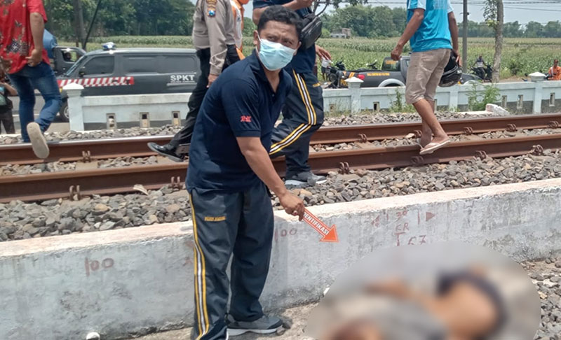 Petugas saat mengevakuasi korban tewas ditabrak kereta api di Jombang.