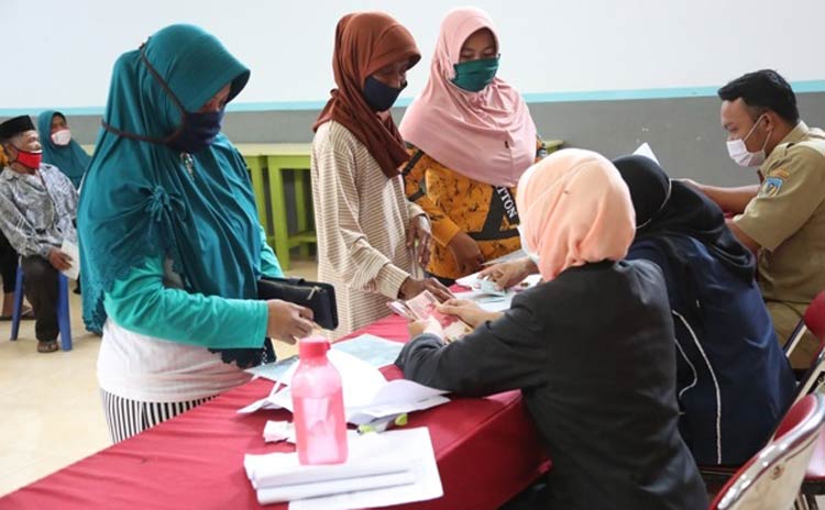 Petugas saat melayani warga yang akan menerima bantuan JPS. (foto: kominfo)