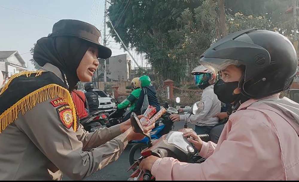 Personel Polwan Polres Mojokerto saat membagikan bunga dan cokelat dalam rangka sosialisasi keselamatan lalu lintas (dok. Ist)