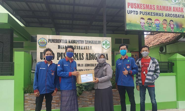 Kepala Puskesmas Arosbaya, Masturah menerima donasi berupa APD face shield dari Forum Mahasiswa Bangkalan. 
