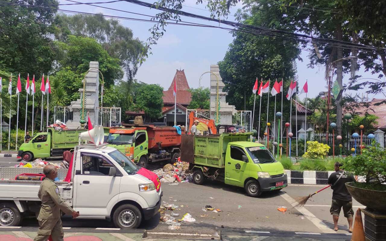 Petugas DLHK Sidoarjo membersihkan sampah yang dibuang pendemo di depan Pendapa Delta Wibawa, Rabu (20/12/2023). Foto: Ist.