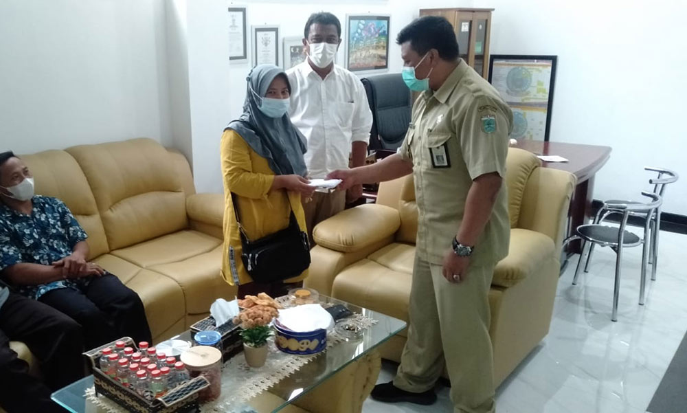 Woko, Kabid Bina Marga mewakili DPUPR Kota Batu menyerahkan bantuan Rp 5 juta kepada Setiyo, istri korban, Solikin, Senin (15/11). Foto: Ist.