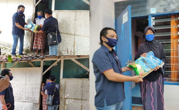 Ketua PWI Sumenep, Roni Hartono saat menyerahkan bantuan beras kepada warga.