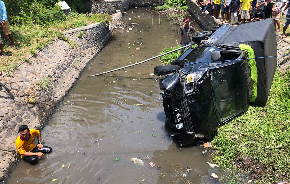 Mobil pikap tercebur ke sungai usai terlibat kecelakaan dengan motor. foto: MUJI HARJITA/ BANGSAONLINE