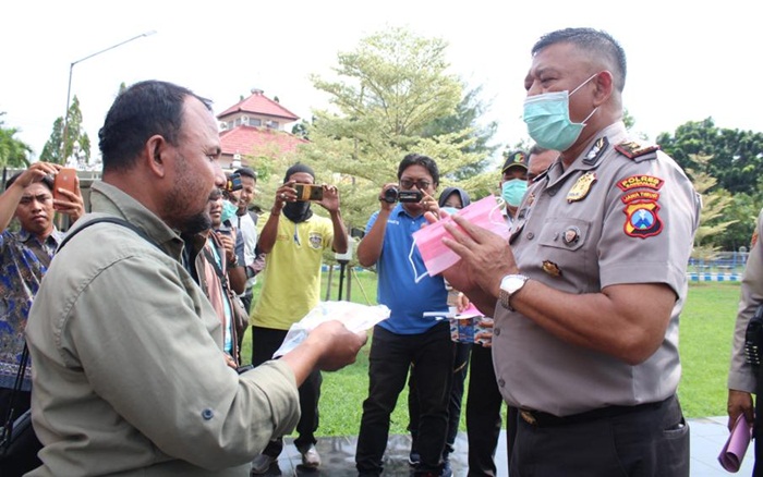 Wakapolres Bangkalan Kompol Deky Hemansyah secara simbolis memberikan vitamin dan masker ke Ahmad Fauzi, salah satu Jurnalis Bangkalan dari HARIAN BANGSA.