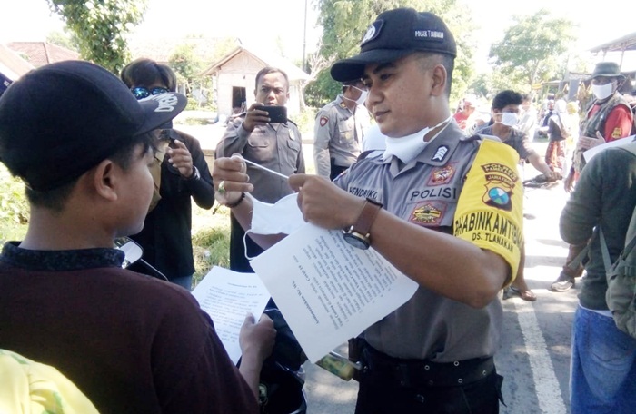 Bripka Hendriko NC membagikan masker kain gratis dan sosialisasi kepada masyarakat sebagai pencegahan mewabahnya Virus Corona (Covid-19).