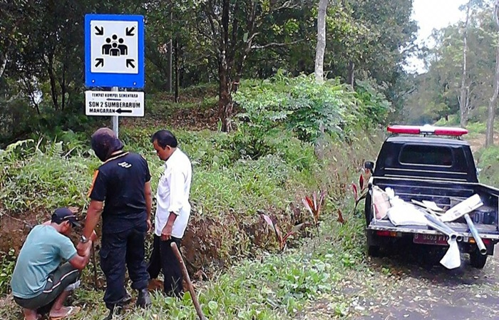 Sejumlah petugas sedang memasang rambu-rambu jalur evakuasi.