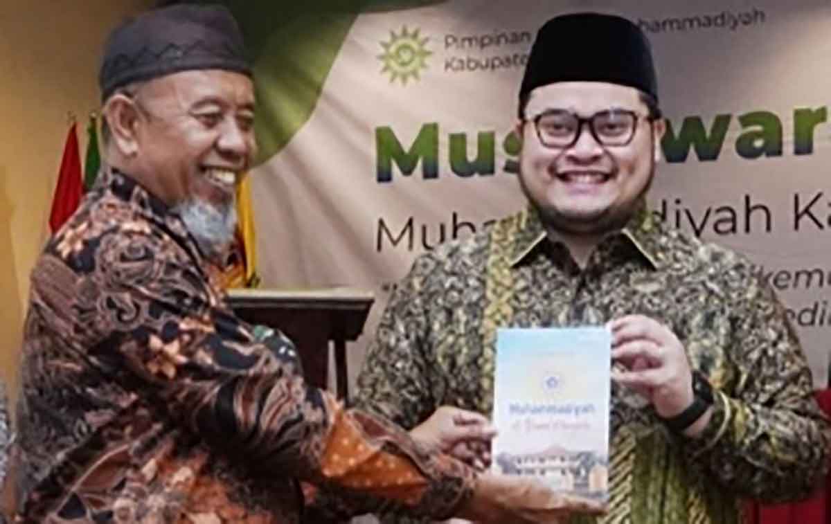 Ketua Pimpinan Daerah Muhammadiyah Kabupaten Kediri, Achmad Fanani Sumali (kiri), saat menyerahkan sebuah buku kepada Bupati Kediri, Hanindhito Himawan Pramana. Foto: Ist