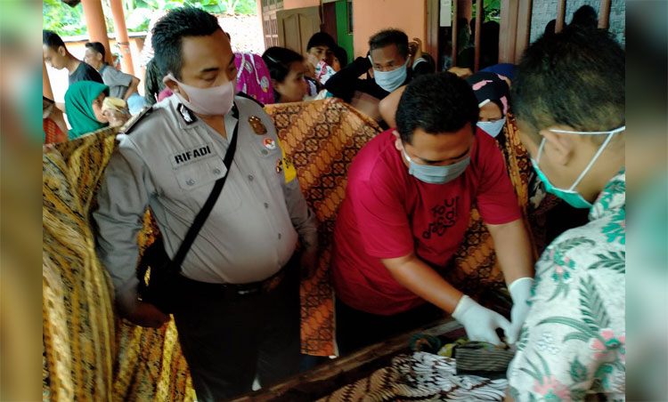 Anggota Polsek Galis saat melakukan pemeriksaan luar terhadap mayat yang ditemukan. 