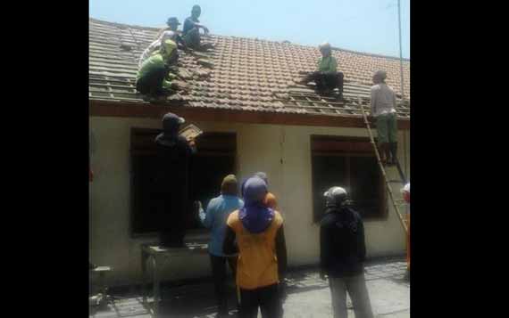BONGKAR: Sejumlah pekerja menurunkan genting  dari rumah yang berdiri di atas lahan sengketa, Kamis (8/10). foto: soewandito/BANGSAONLINE