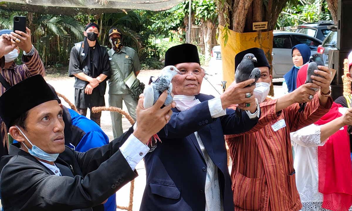 Ketua Harian Situs Ndalem Pojok Persada Sukarno, Kushartono (kiri) ketika akan melepaskan burung merpati yang membawa surat untuk Presiden Jokowi bersama peserta upacara yang lain. foto: MUJI HARJITA/ BANGSAONLINE
