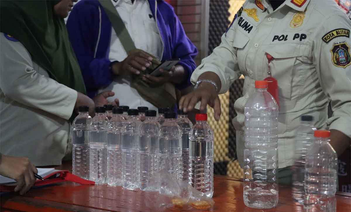 Petugas gabungan saat memeriksa miras atau minuman keras yang diperjualbelikan di Kota Blitar.