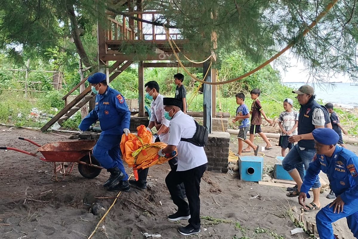 Petugas saat mengevakuasi potongan tubuh manusia yang ditemukan di pesisir pantai kawasan Kampung Lobster Banyuwangi