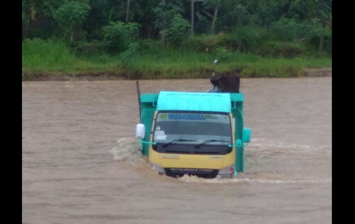 Truk yang gagah berani ini akhirnya berhasil menyeberangi sungai saat banjir bandang datang. Dalam kondisi nyaris terbenam air, truk berusaha menyeberang sungai dari hutan sebelah. 