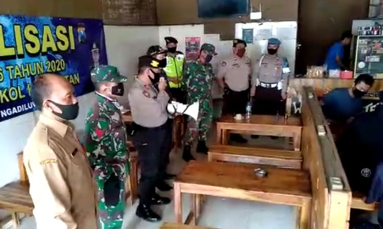 Anggota Forkopimcam Ngadiluwih saat menyosialisasikan Inpres No. 6 Tahun 2020 di sebuah warung kopi. 